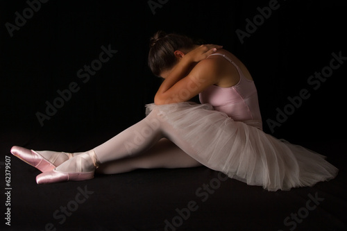Obraz na plátně Female dancer sit on floor looking sad in pink tutu