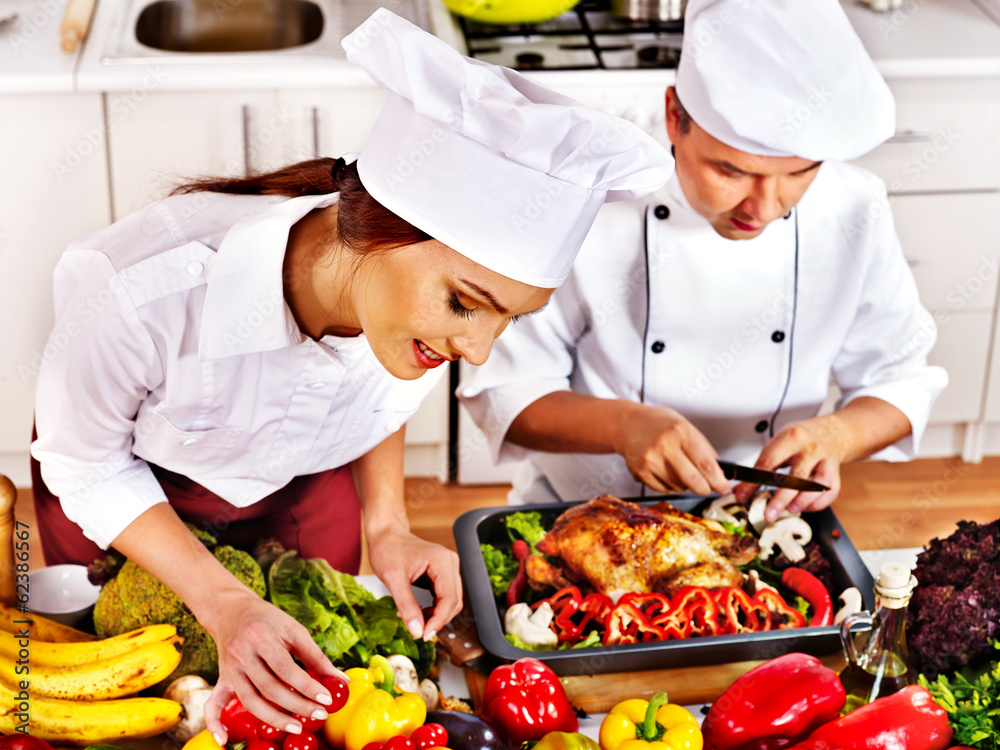 Man and woman in chef hat cooking chicken Man and woman in chef hat cooking chicken