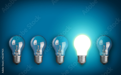 Idea concept with row of light bulbs and glowing bulb photo