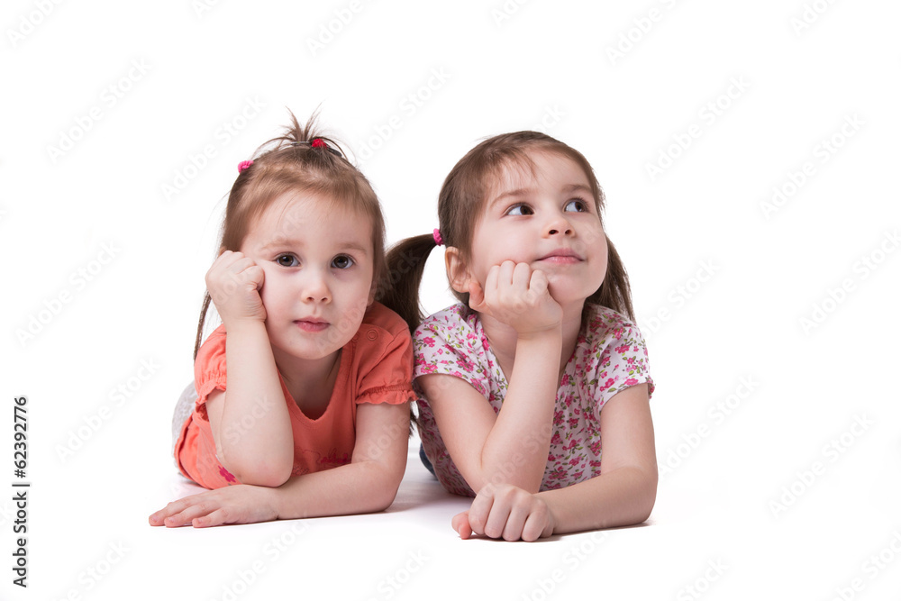 Little girls lying on the floor looking to the copy space аrе Little girls lying on the floor looking to the copy space аrе