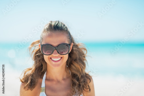 Portrait of young woman in sunglasses on beach