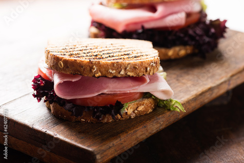 Sandwich with ham salad tomato on cutting board photo