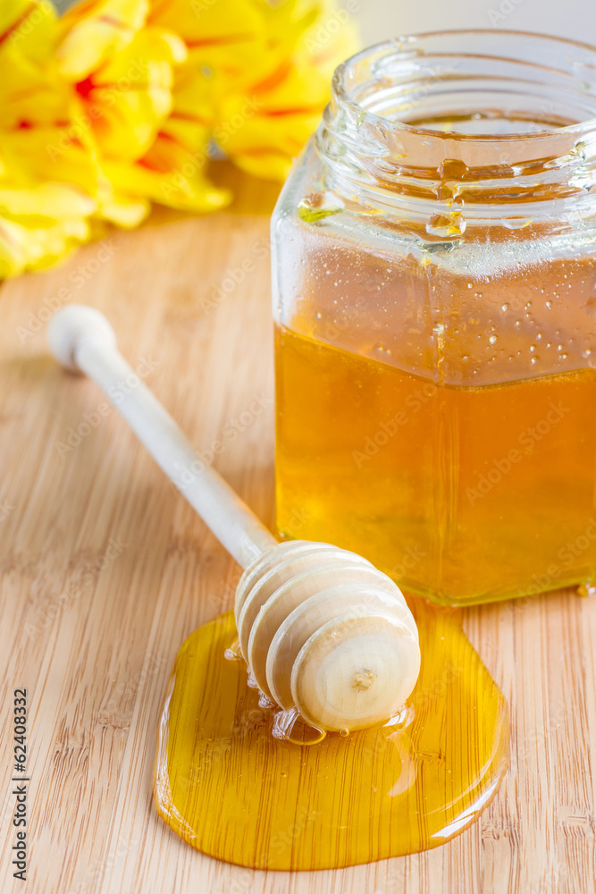 honey dipper on a background of a jar with honey honey dipper on a background of a jar with honey