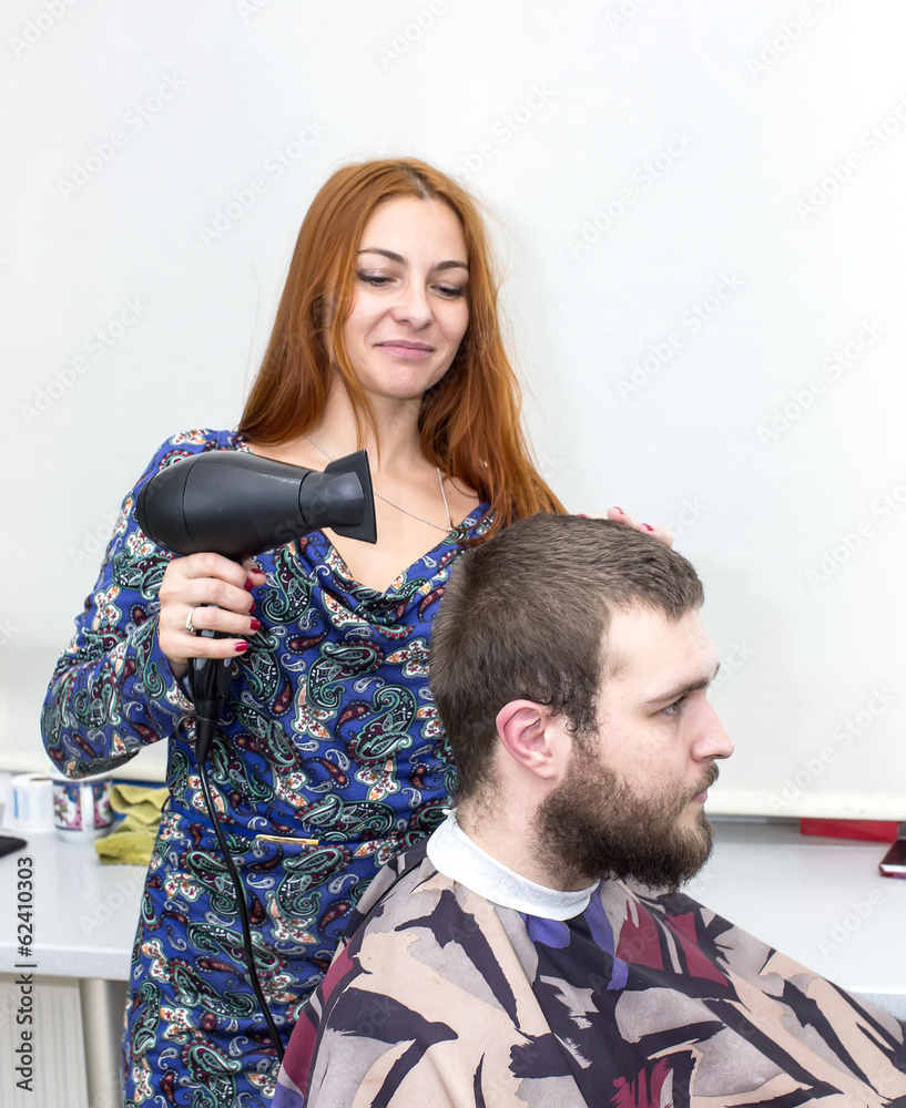 Naklejka premium girl doing hairstyle at the guy