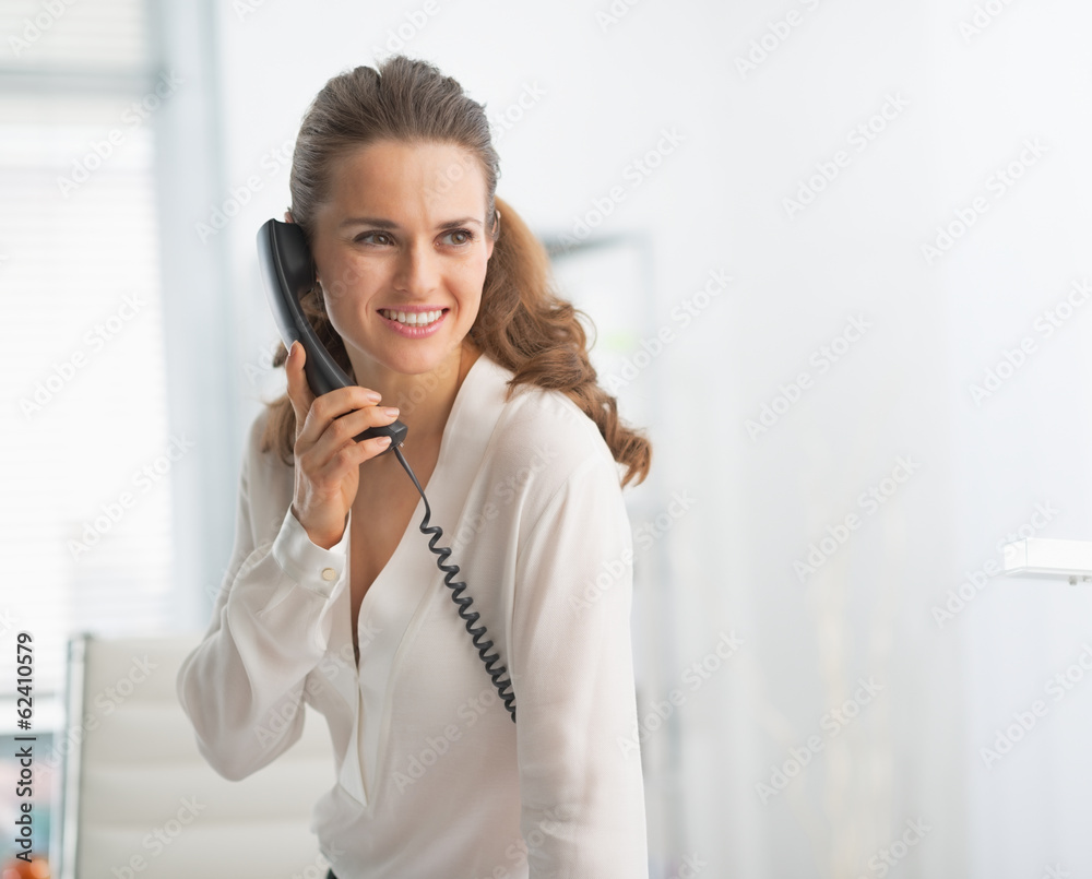 Modern business woman in office talking phone Modern business woman in office talking phone