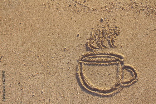 Vintage coffee cup  drawn on sand beach,filtered image