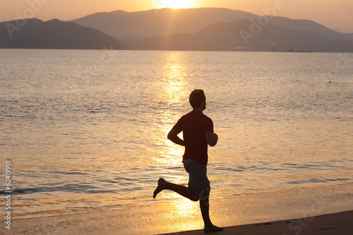 Silhouette of runner on the beach at sunset