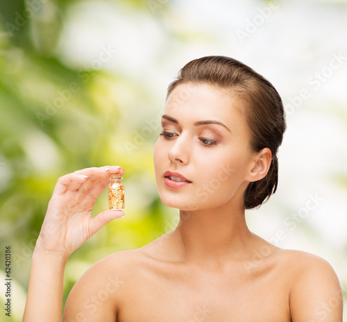 beautiful woman showing bottle with golden dust