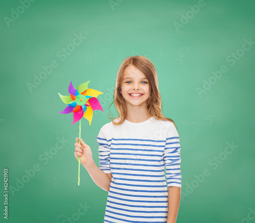 smiling child with colorful windmill toy
