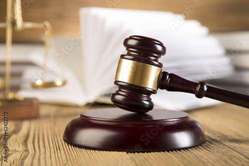 Golden scales of justice, gavel and books wood brown background 