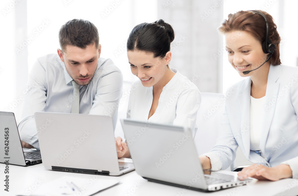 group of people working with laptops in office group of people working with laptops in office