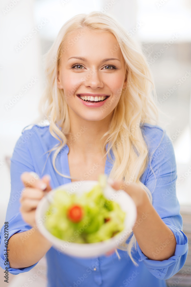 smiling young woman with green salad at home smiling young woman with green salad at home