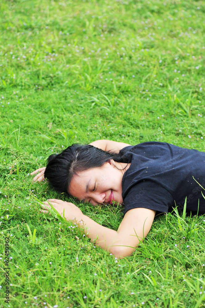 young asian woman laying down on green grass young asian woman laying down on green grass