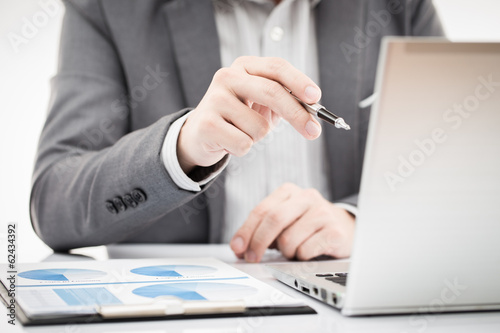 Businessman analyzing investment charts with laptop