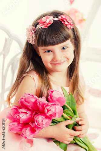 Adorable little girl with bouquet of tulips