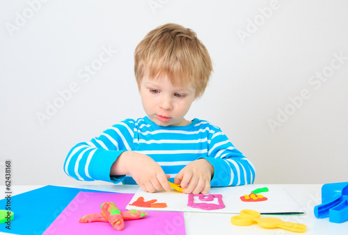 little boy playing with clay dough
