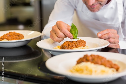 Closeup of a male chef garnishing food