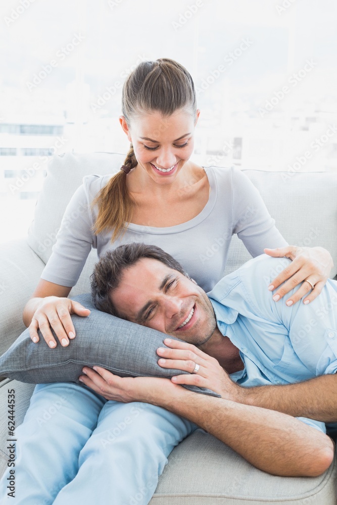 Smiling couple relaxing on the couch together Smiling couple relaxing on the couch together