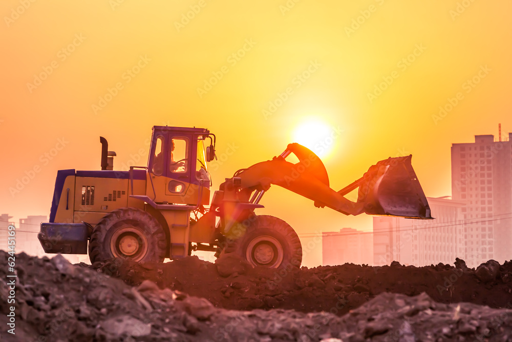 heavy wheel excavator machine working at sunset heavy wheel excavator machine working at sunset