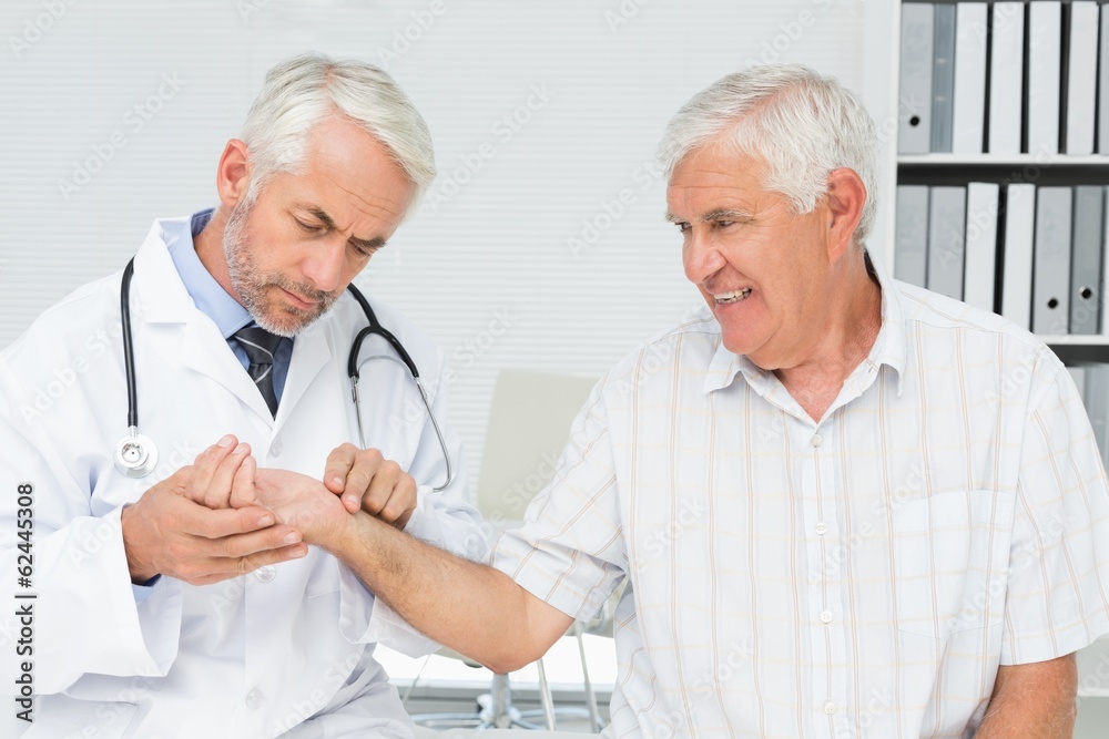 Male doctor taking a senior patients pulse Male doctor taking a senior patients pulse