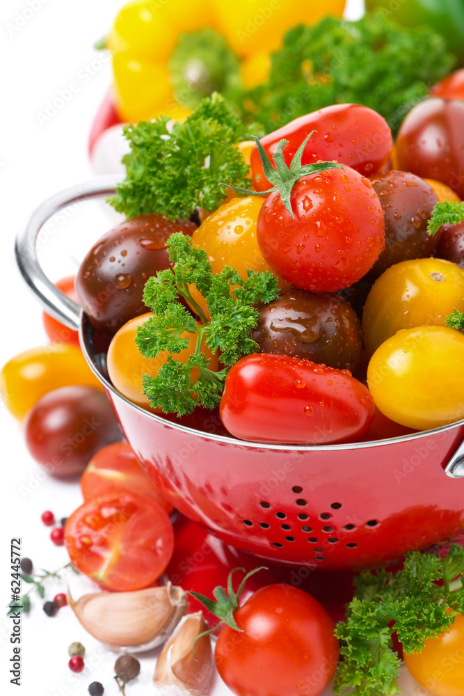 Assorted cherry tomatoes in a colander, spices and fresh herbs Assorted cherry tomatoes in a colander, spices and fresh herbs