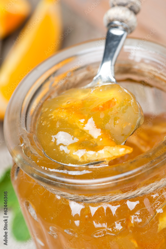 spoon of orange marmalade in a glass jar spoon of orange marmalade in a glass jar