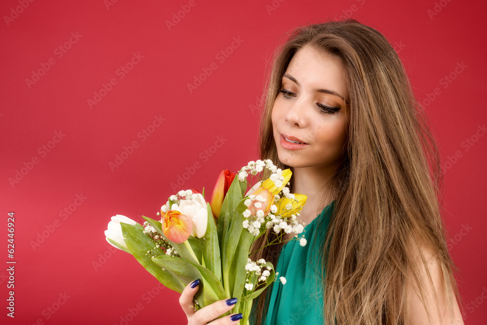 Beautiful girl in a summer dress with tulips on a red background Beautiful girl in a summer dress with tulips on a red background
