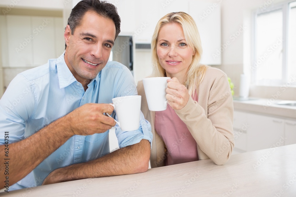 Portrait of happy couple with coffee cups in kitchen Portrait of happy couple with coffee cups in kitchen