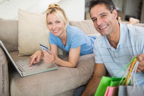 Portrait of smiling couple doing online shopping at home