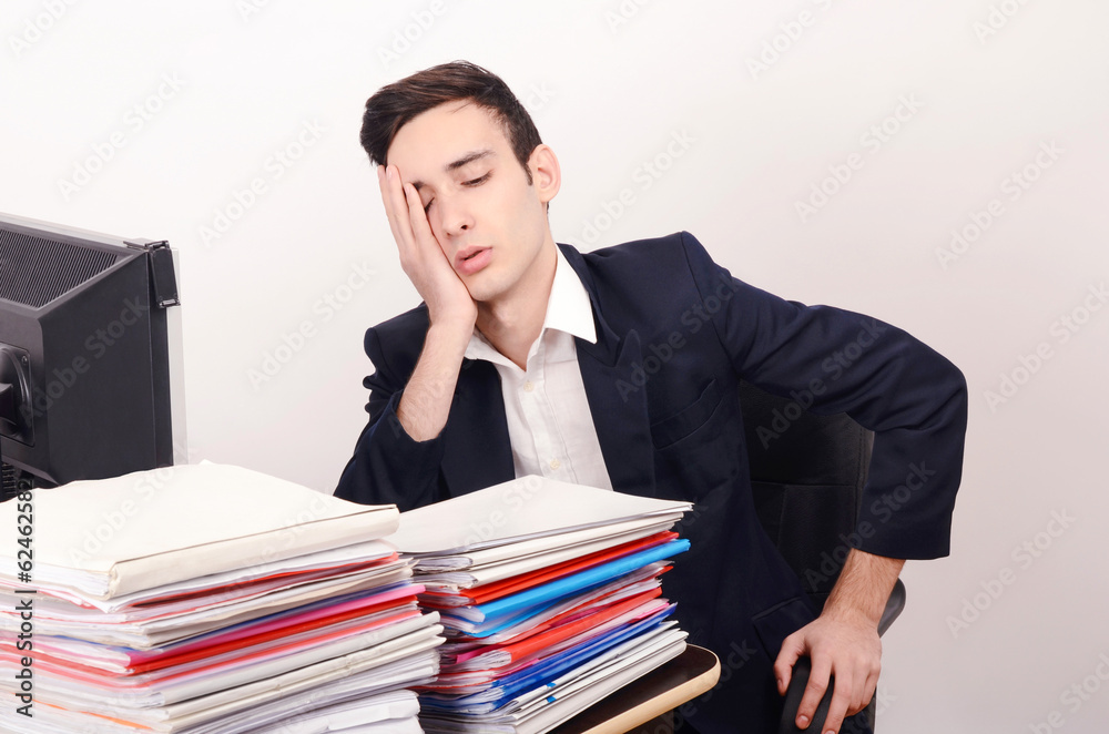 Worried tired business man with a big pile of files to work on. Worried tired business man with a big pile of files to work on.