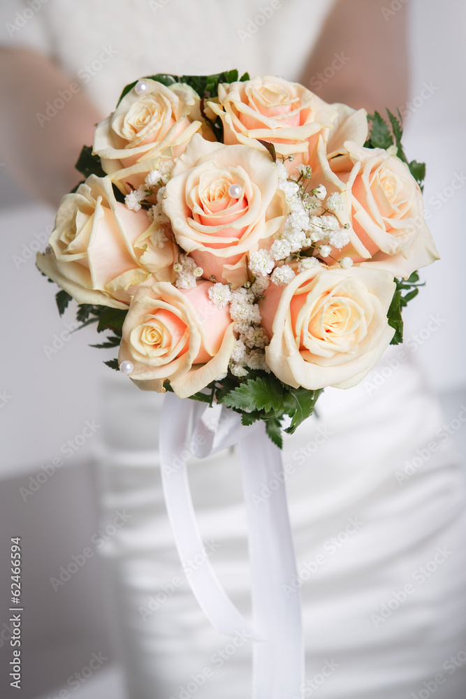 Obraz premium Bride holding wedding bouquet of roses close up