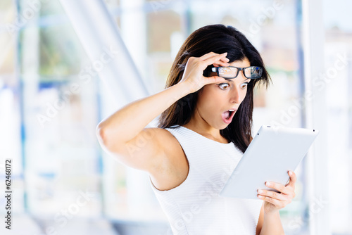 Surprised modern businesswoman with tablet photo