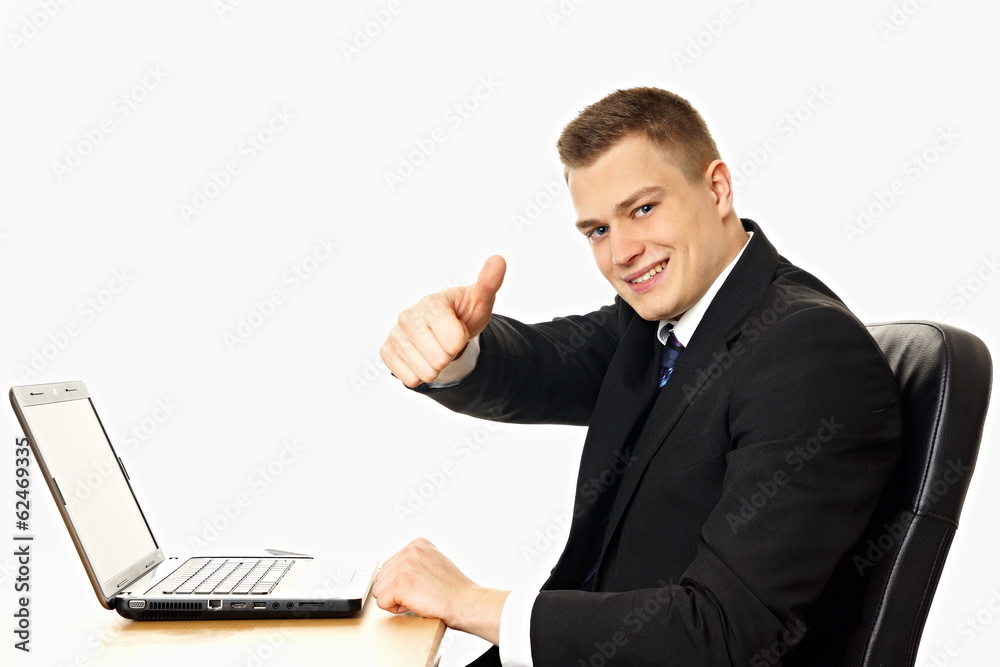 Handsome businessman at the computer shows finger up Handsome businessman at the computer shows finger up