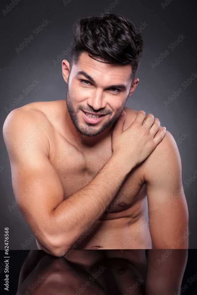 naked man smiles with hand on shoulder naked man smiles with hand on shoulder