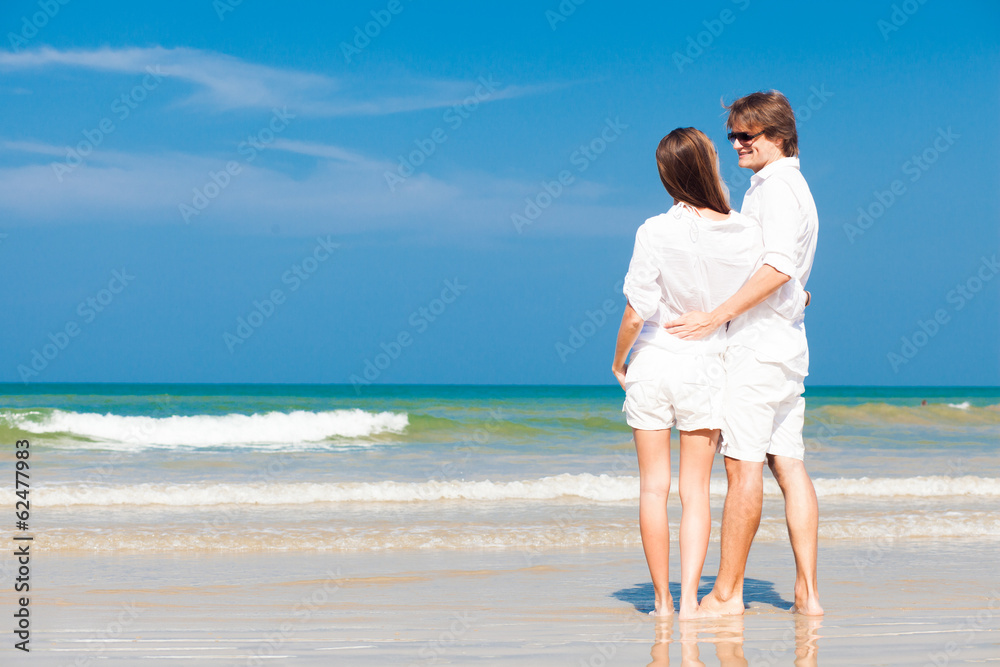 Couple in white clothes on tropical beach in Thailand