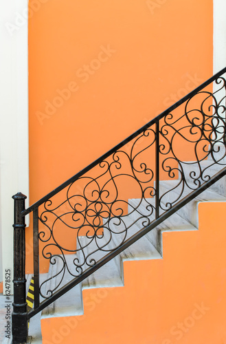 Stairs and railing with orange wall background