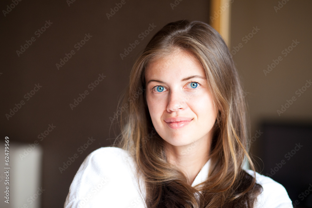 beautiful woman in bathrobe smiling in hotel room