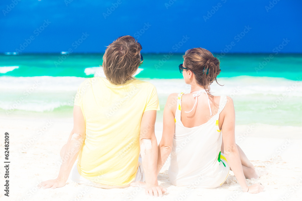 young happy couple sitting on tropical beach honeymoon young happy couple sitting on tropical beach honeymoon