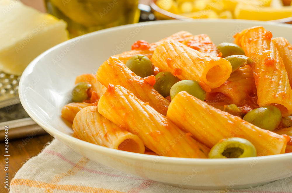 Tortiglioni con pomodoro e olive, cucina italiana Tortiglioni con pomodoro e olive, cucina italiana