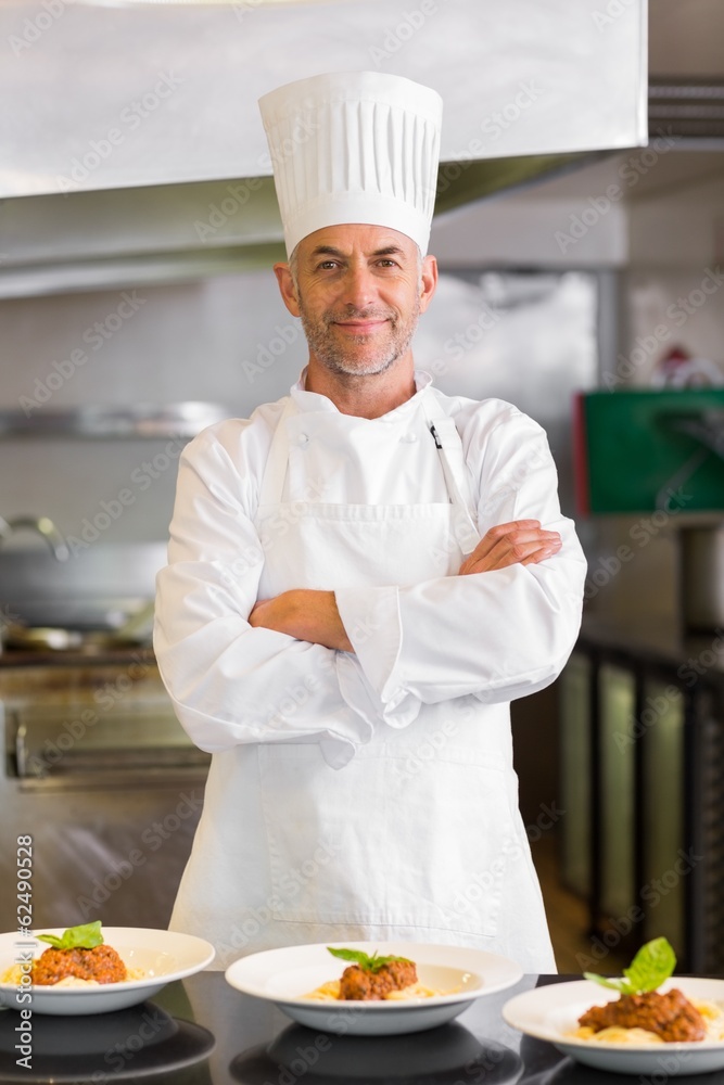 Confident male chef with cooked food in kitchen Confident male chef with cooked food in kitchen