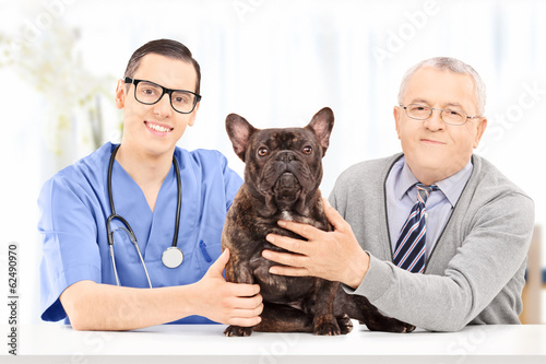 Senior adult posing with his dog at a veterinary practice