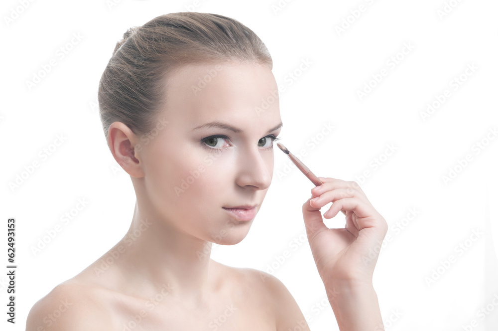 Girl with eyelid brush, isolated on white