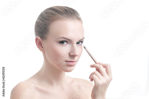 Girl with eyelid brush, isolated on white