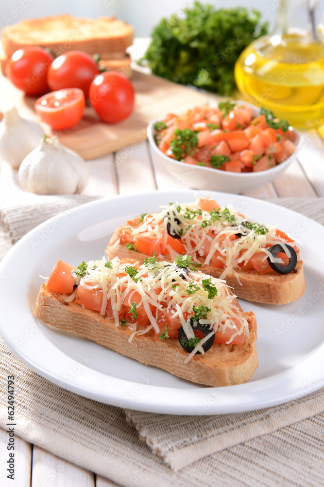 Delicious bruschetta with tomatoes on plate on table close-up Delicious bruschetta with tomatoes on plate on table close-up