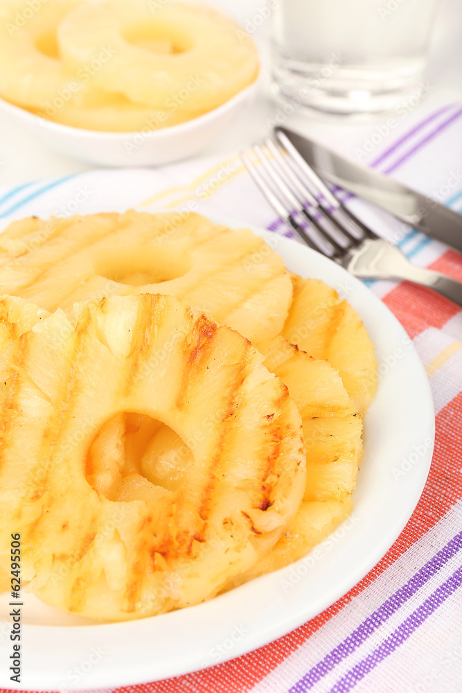 Juicy grilled pineapple on plate on table close-up Juicy grilled pineapple on plate on table close-up