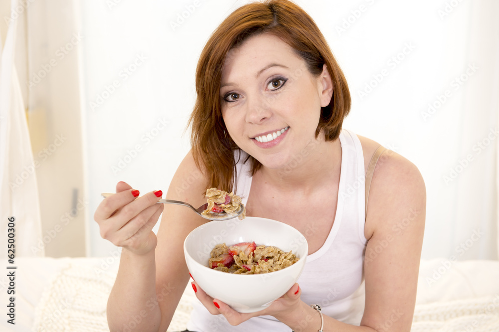 red haired happy woman eatting cereal and stawberries red haired happy woman eatting cereal and stawberries