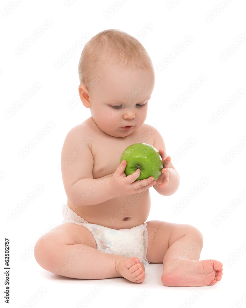 Happy child baby boy sitting in diaper with green apple Happy child baby boy sitting in diaper with green apple