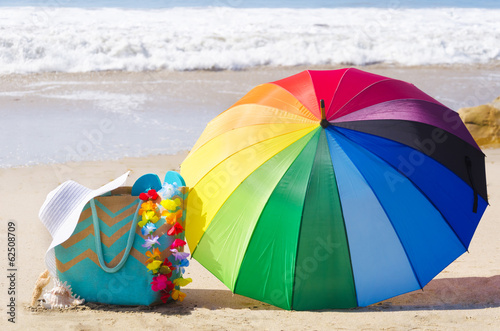 Summer background with rainbow umbrella and beach bag © ellensmile