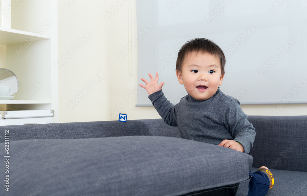 Asian little boy sitting on sofa