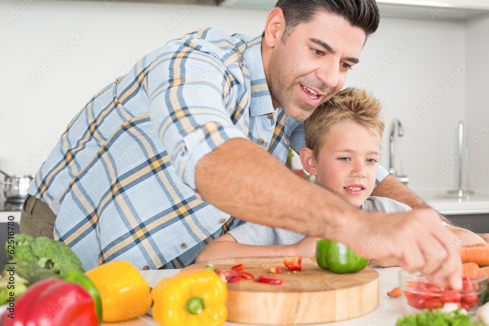 Handsome father showing his son how to prepare vegetables Handsome father showing his son how to prepare vegetables